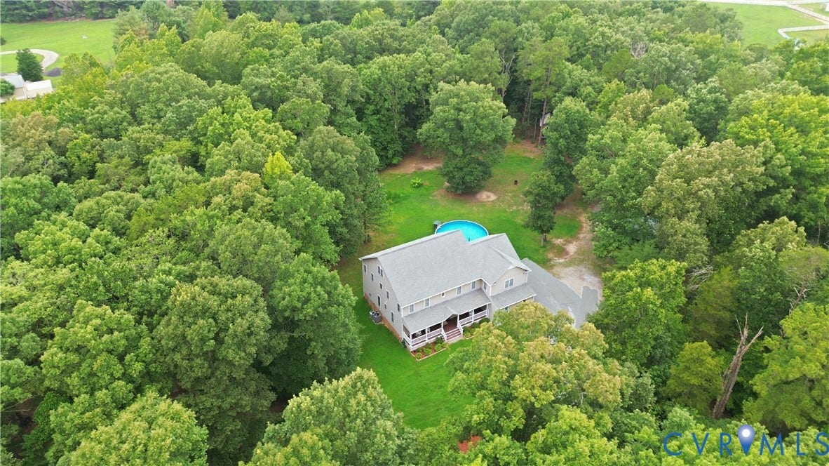 1836 Rocky Ford Road, Powhatan, VA 23139 Expansive wooded acreage featuring a residence with vinyl siding exterior, a gray shingle roof, and a full-length front porch