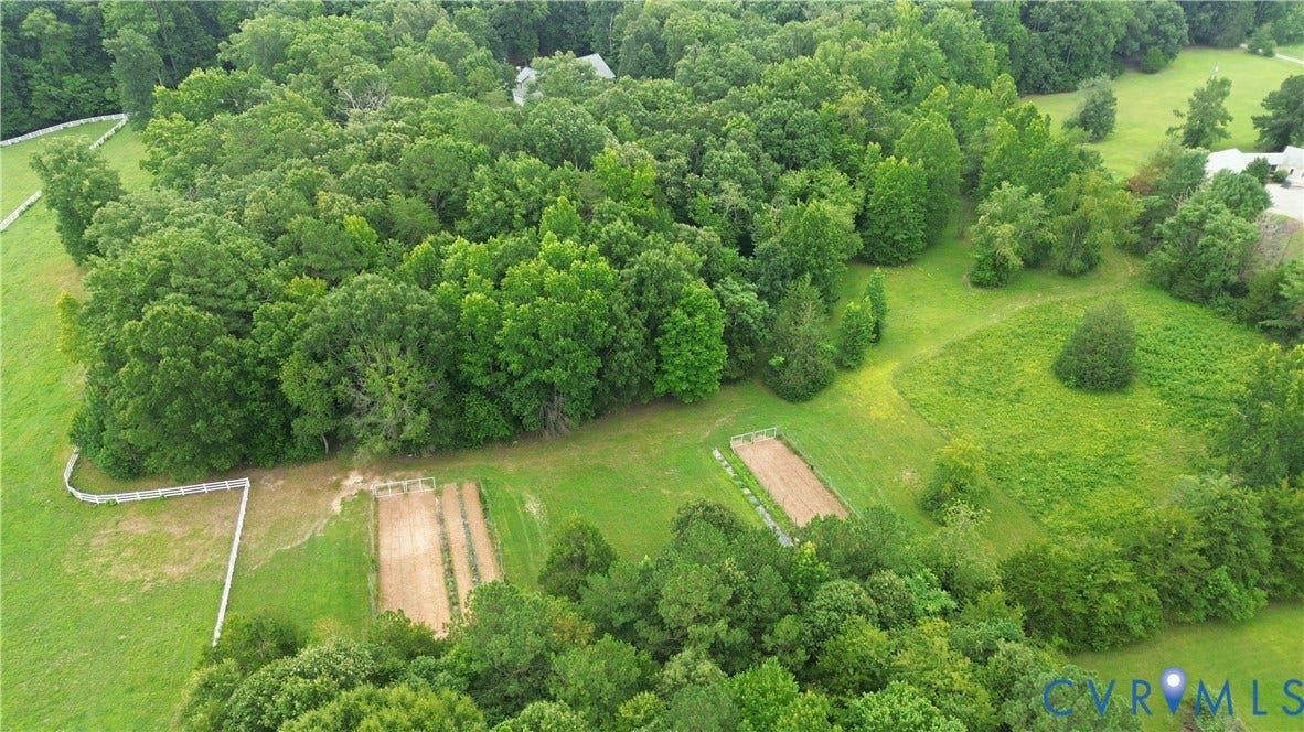 1836 Rocky Ford Road, Powhatan, VA 23139 Expansive verdant property featuring densely wooded areas, open grassy fields, two distinct garden plots, and a white fence border