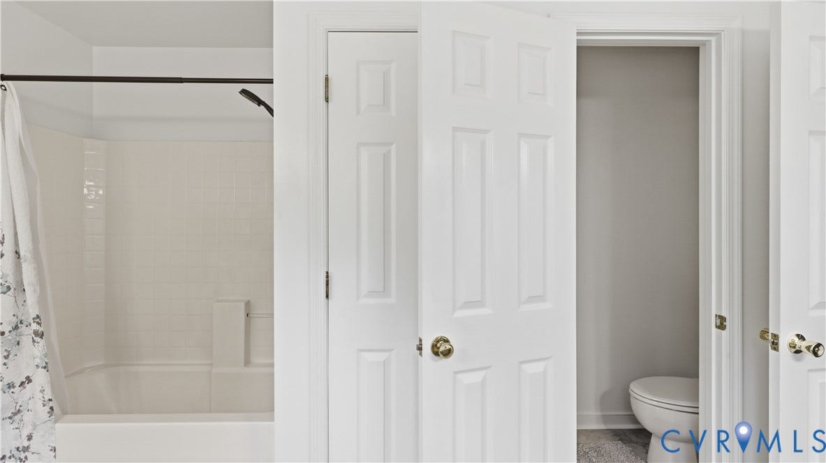 1836 Rocky Ford Road, Powhatan, VA 23139 Jack and Jill bathroom with a white paneled tub and shower combination with subway tile surround and a matte black shower head