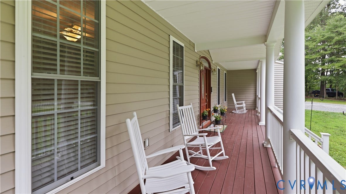 1836 Rocky Ford Road, Powhatan, VA 23139 Inviting covered front porch featuring a rich wood-finish deck, white railing, and substantial white support columns