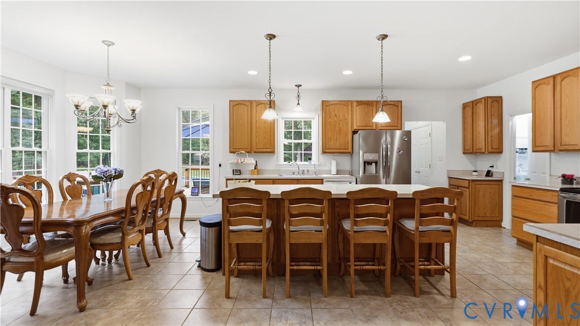 1836 Rocky Ford Road, Powhatan, VA 23139 Open-concept kitchen and dining area featuring light wood cabinetry, stainless steel appliances, a center island with seating, and tile flooring