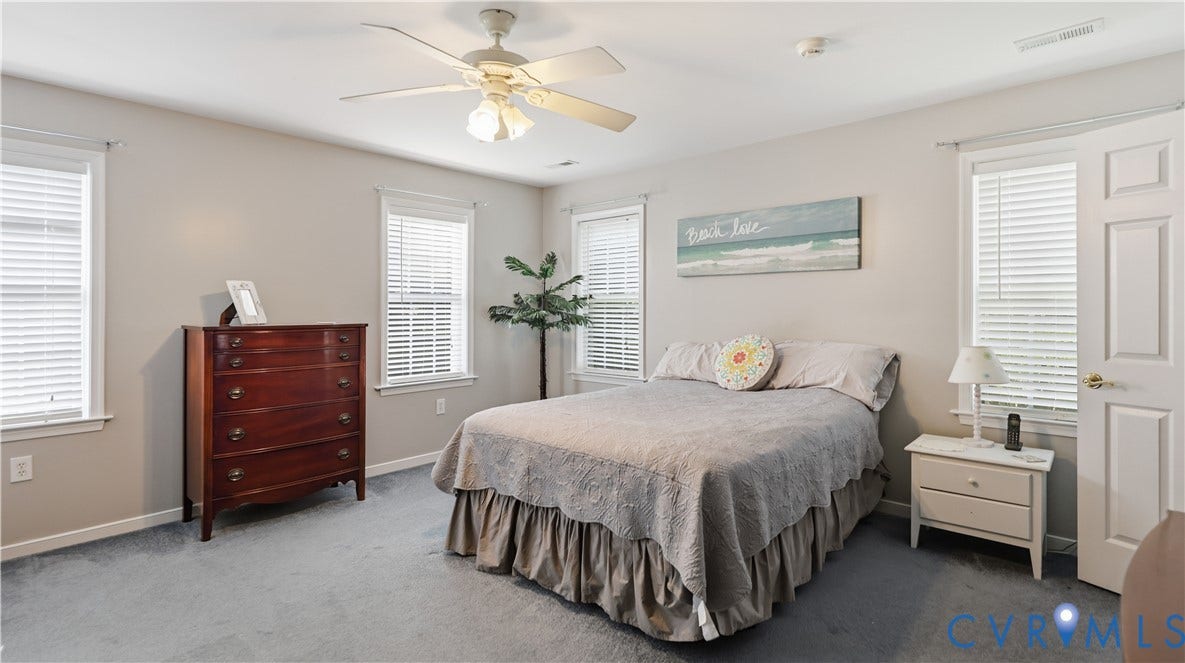 1836 Rocky Ford Road, Powhatan, VA 23139 Carpeted room featuring multiple windows with blinds, a ceiling fan with integrated lighting, and a white paneled door