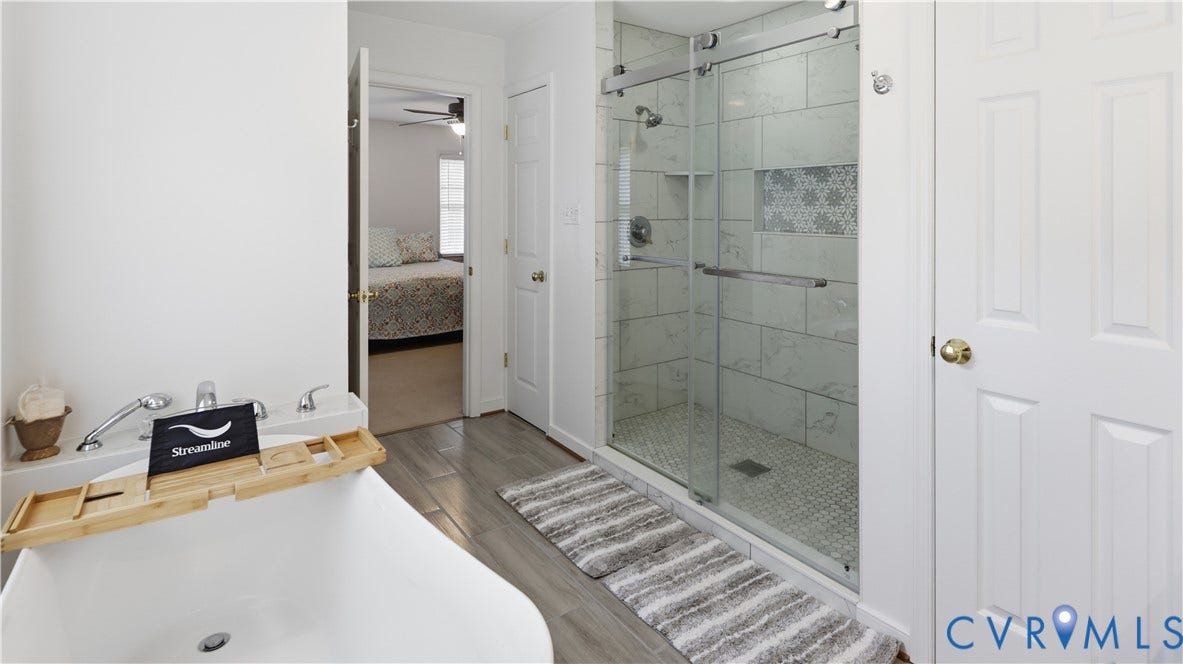 1836 Rocky Ford Road, Powhatan, VA 23139 Bathroom featuring a freestanding tub with deck-mounted fixtures, a glass-enclosed shower with subway tile surround, patterned accent tile, and a built-in shower niche
