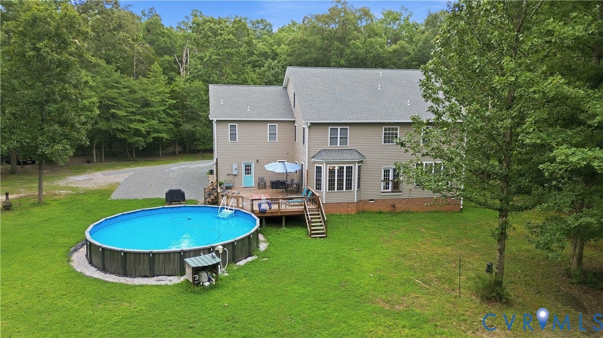 1836 Rocky Ford Road, Powhatan, VA 23139 Expansive rear exterior featuring a large above-ground pool, a multi-level wood deck, and a bay window