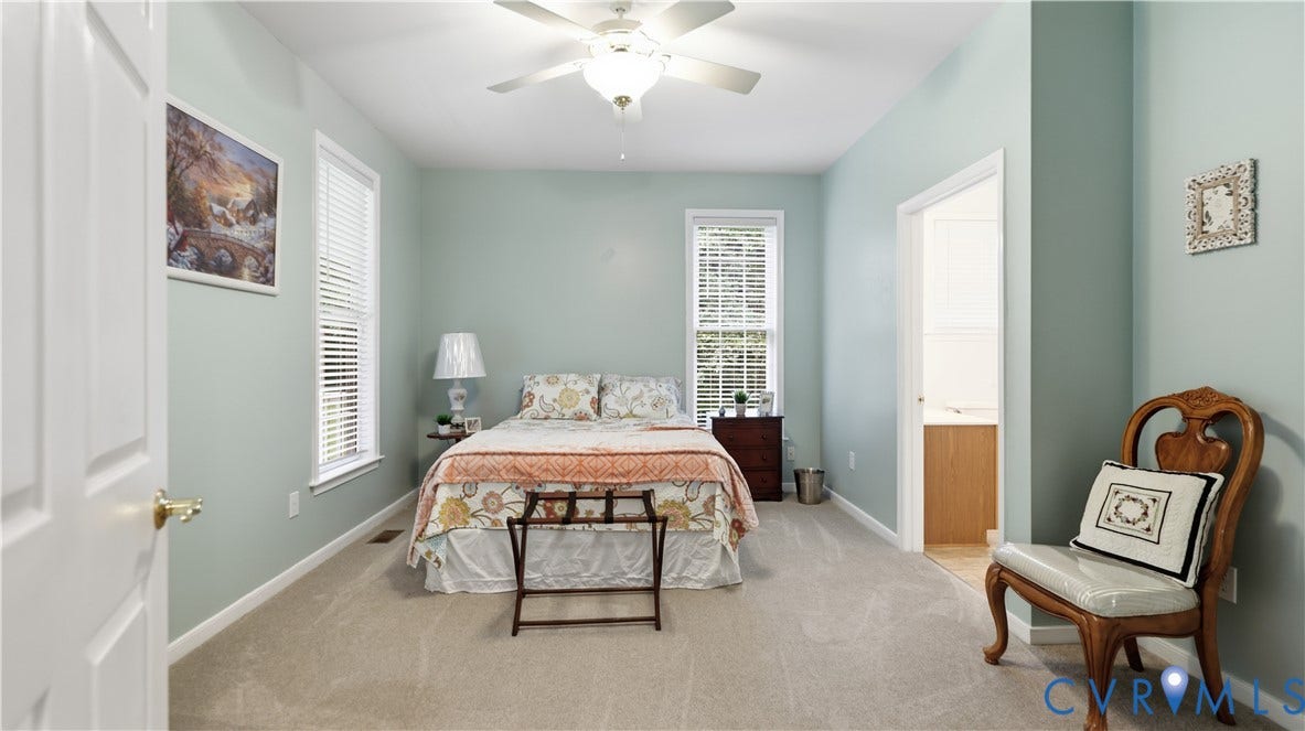 1836 Rocky Ford Road, Powhatan, VA 23139 Bedroom featuring light-colored carpet flooring, two windows with blinds, a ceiling fan with integrated lighting, and a white interior door with brass hardware