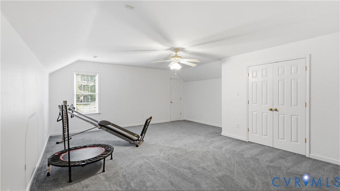 1836 Rocky Ford Road, Powhatan, VA 23139 Spacious room with sloped ceilings, light gray carpeting, and a ceiling fan