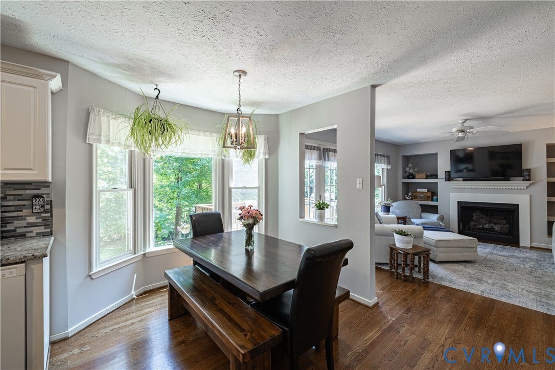 Dining area featuring a bay window, hardwood flooring, and a contemporary chandelier
