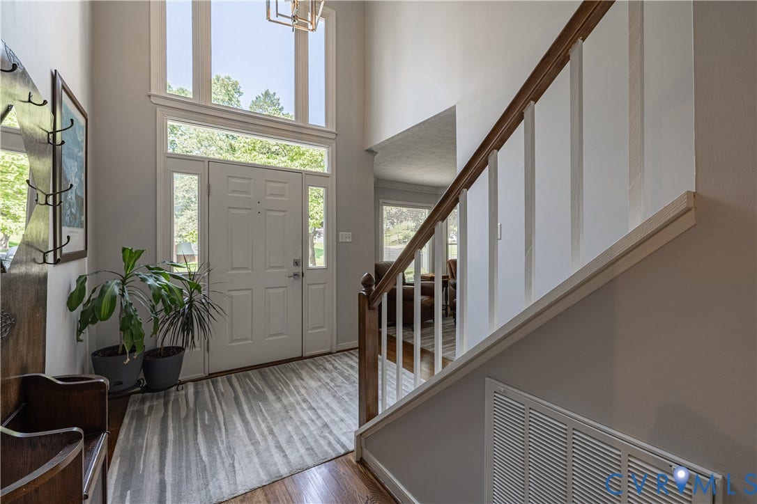 Two-story foyer with a paneled entry door, sidelight windows, and transom windows