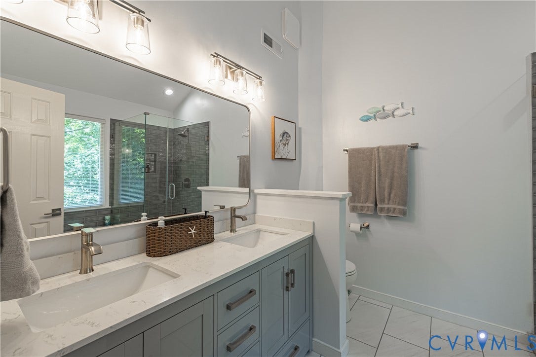 Double vanity with light gray cabinetry and white countertops