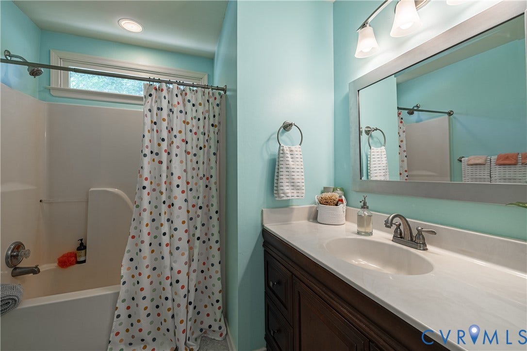 Bathroom featuring a single vanity with a white countertop and dark wood-finish cabinetry