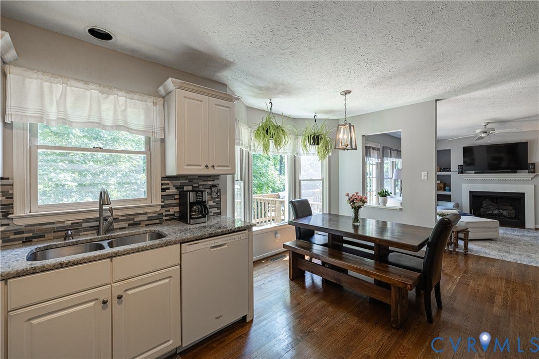 Kitchen featuring white cabinetry, granite countertops, and a tiled backsplash