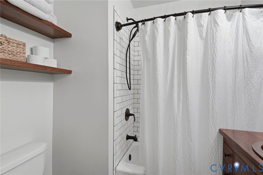 3332 Parkwood Avenue, Carytown, Richmond, VA 23221 White subway tile shower surround with dark bronze fixtures and a curved shower rod