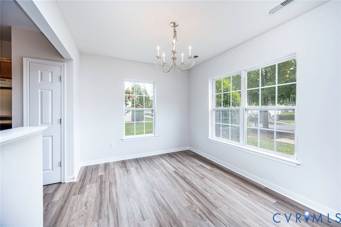 2802 Goyne Terrace, Chester, VA 23831 Dining space featuring wood-finish flooring, two large windows, and a multi-arm chandelier