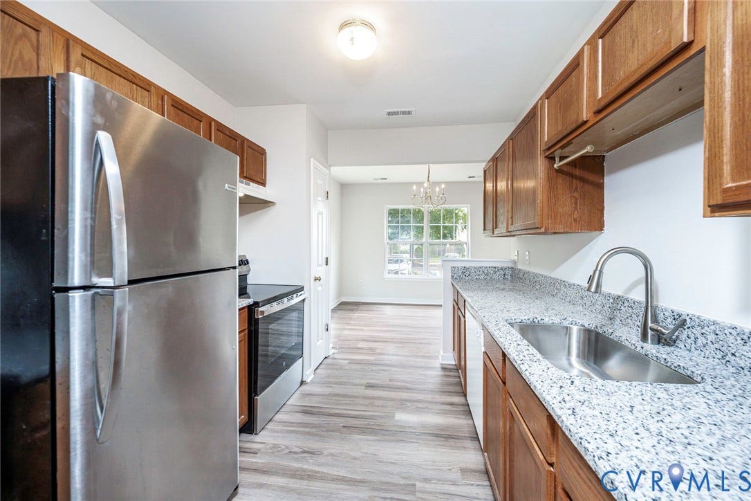 2802 Goyne Terrace, Chester, VA 23831 Galley kitchen featuring wood-finish cabinetry, stainless steel appliances, and wood-finish flooring