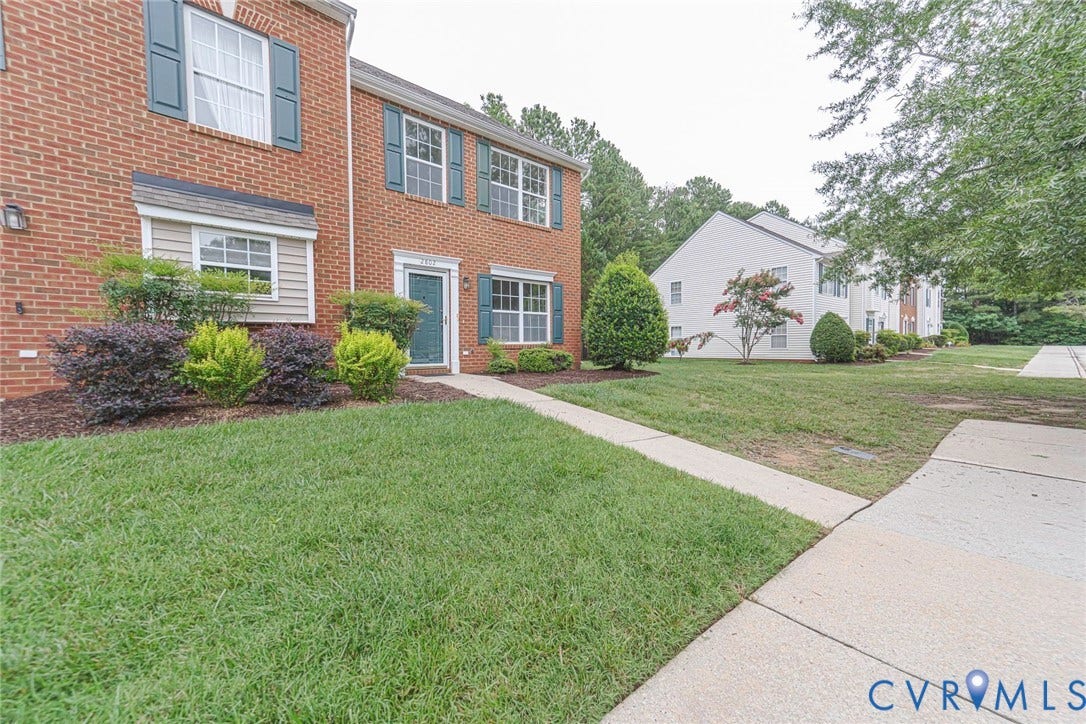 2802 Goyne Terrace, Chester, VA 23831 Brick exterior featuring a teal front door with sidelights, a landscaped planting bed, and a concrete walkway