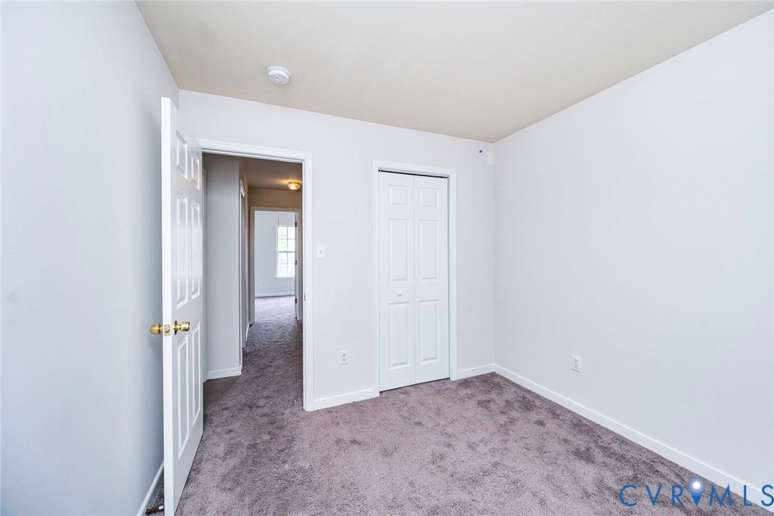 2802 Goyne Terrace, Chester, VA 23831 Carpeted room with white walls, a bi-fold closet, and a paneled door with brass hardware