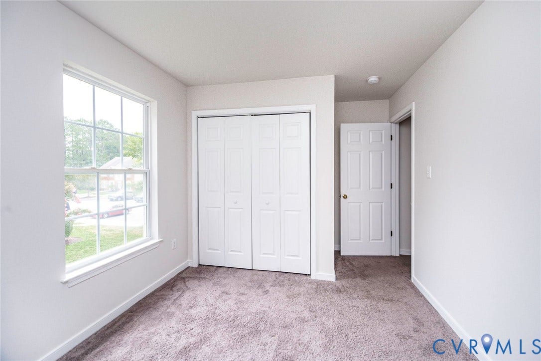 2802 Goyne Terrace, Chester, VA 23831 Bright room featuring a double-hung window, white trim, bi-fold closet doors, a paneled interior door, and carpet flooring