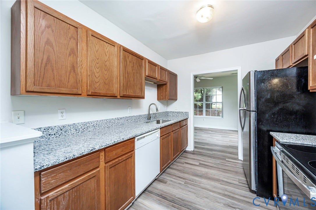 2802 Goyne Terrace, Chester, VA 23831 Kitchen featuring wood cabinetry, light-toned countertops, stainless steel sink, and wood-finish flooring