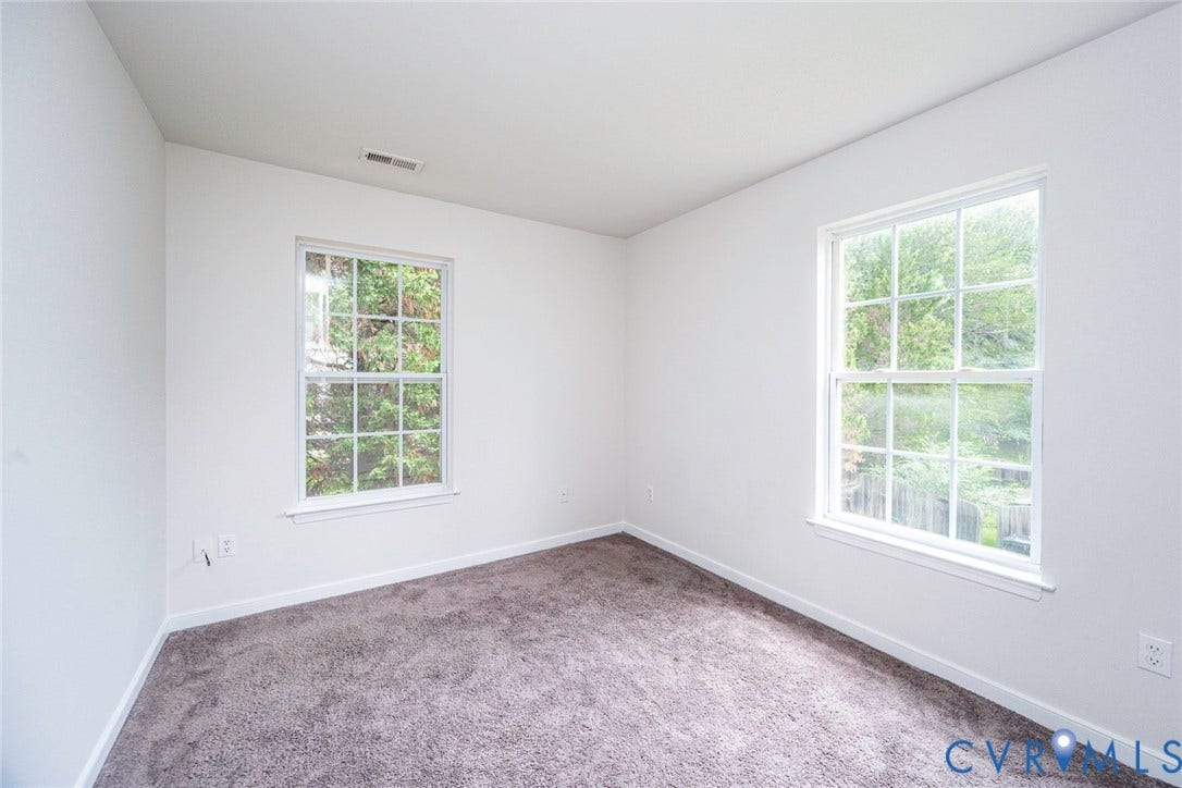 2802 Goyne Terrace, Chester, VA 23831 Bright interior room featuring a neutral color palette, two double-hung windows with white frames, and plush gray carpeting