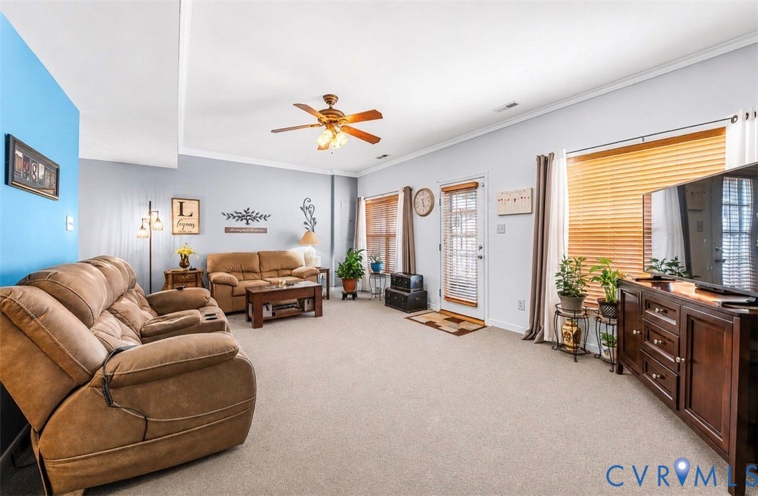 958 Wellston Court, Glen Allen, VA 23059 Carpeted living space featuring light gray walls, a partial accent wall, a ceiling fan, and multiple windows with horizontal blinds