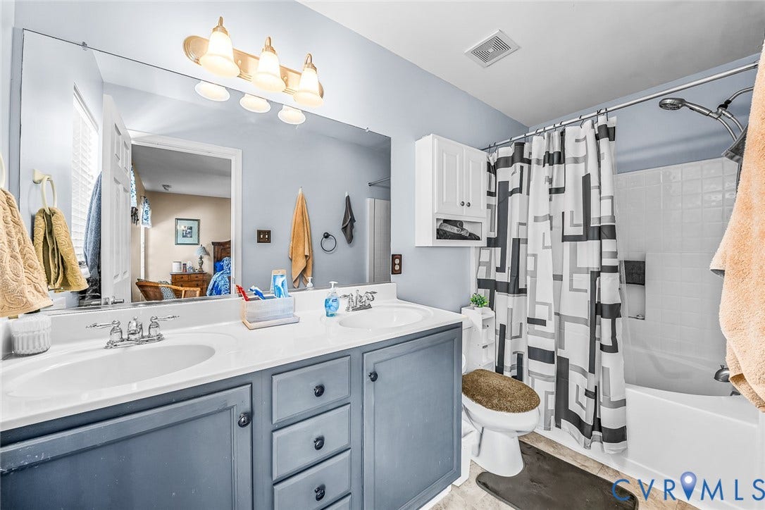 958 Wellston Court, Glen Allen, VA 23059 Bathroom featuring a dual vanity with a light countertop, a built-in tub with shower, and a large wall-mounted mirror