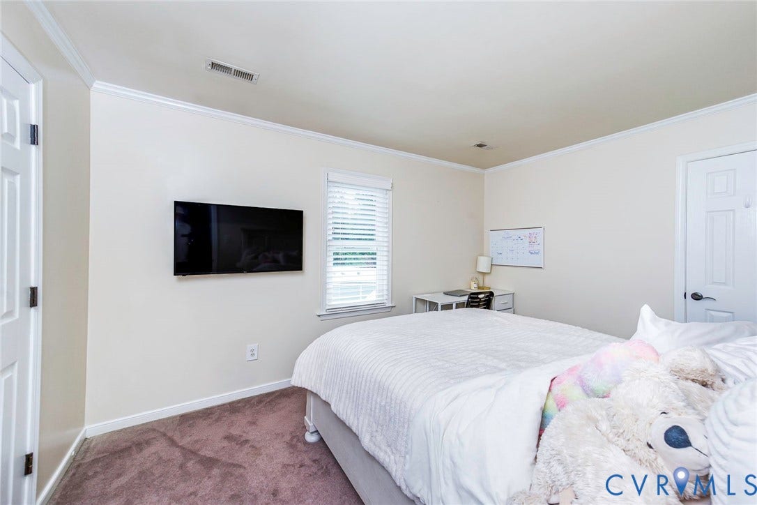 Carpeted room featuring crown molding, a single window with blinds, and white paneled doors