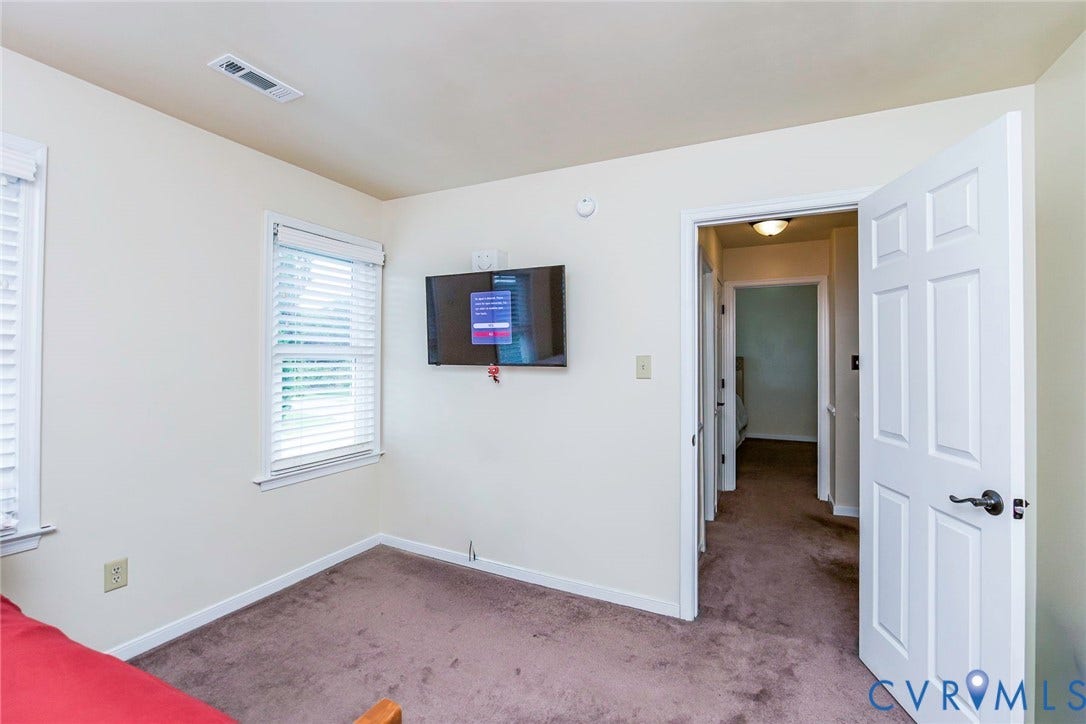 Interior room featuring light-colored walls and brown carpeting