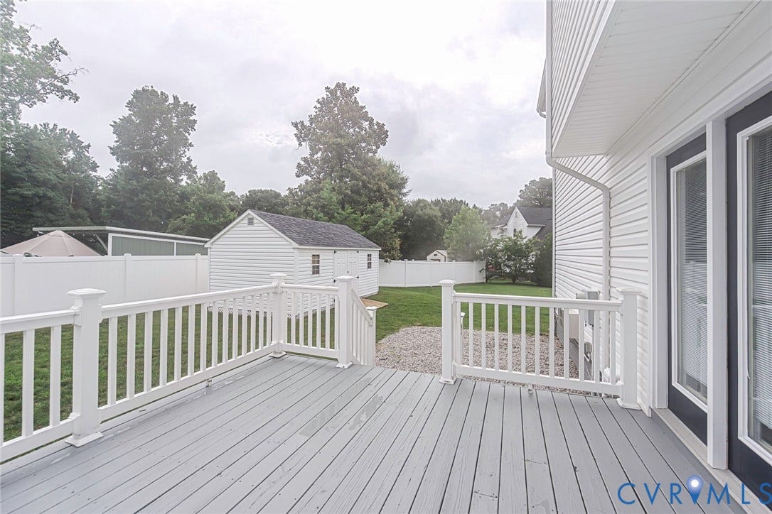 Spacious outdoor deck with white railing, gray-finish decking, and direct access to the backyard