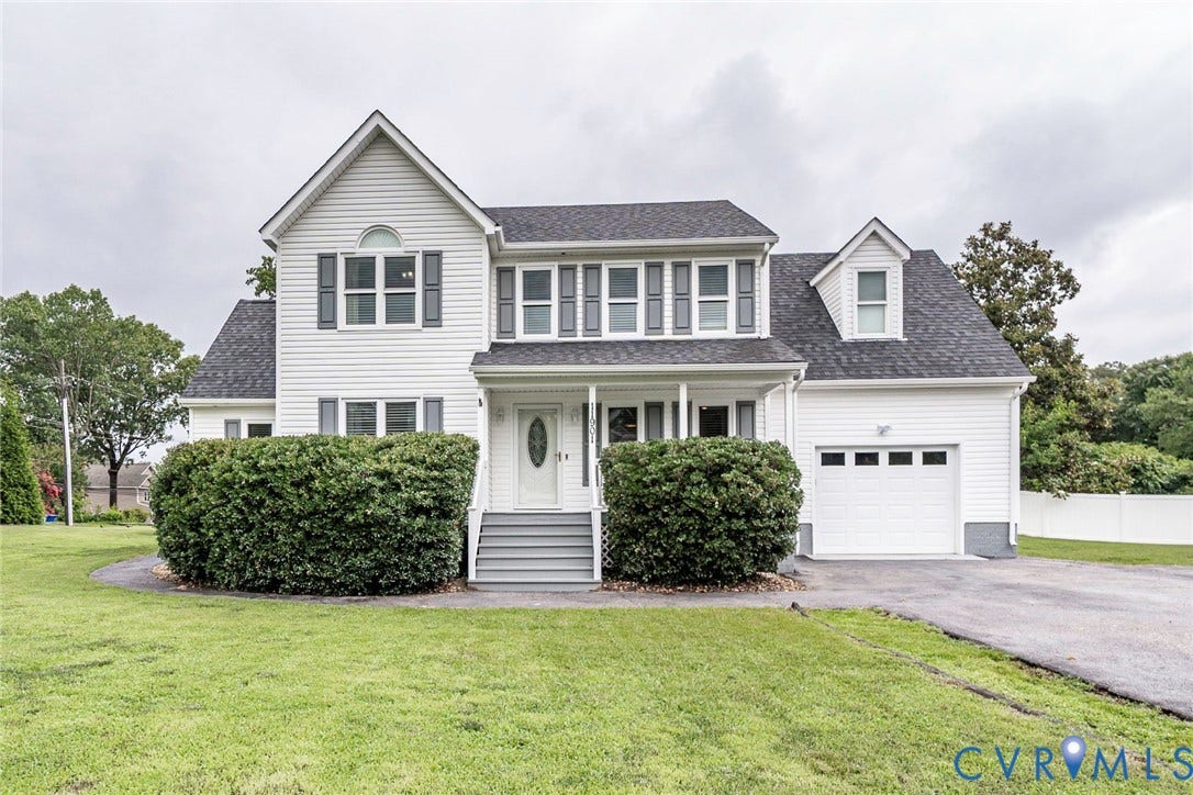 Two-story siding exterior with dark shutters, covered front entry, attached single-car garage, and established front landscaping