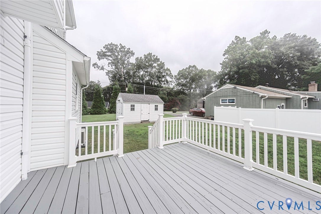 Spacious outdoor deck with painted wood-finish flooring and white railing