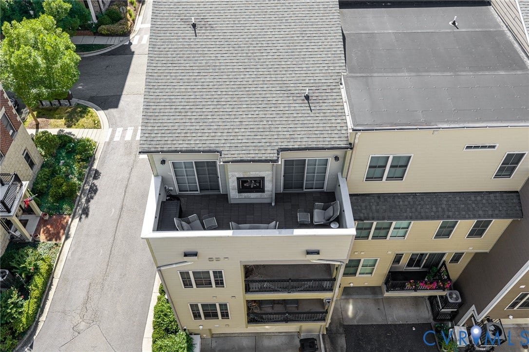 Expansive rooftop terrace featuring a built-in outdoor fireplace, tiled flooring, and sliding glass door access