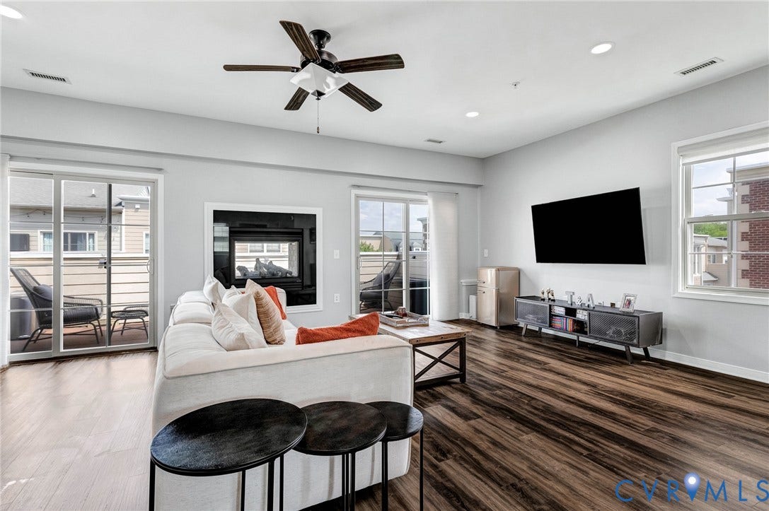 Spacious living area featuring wood-finish flooring, a ceiling fan, and recessed lighting