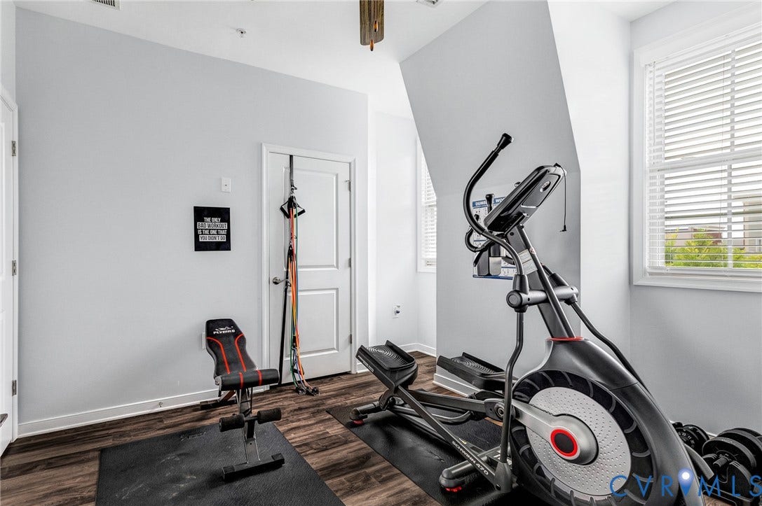 Room featuring wood-finish flooring, white baseboards, and light gray walls