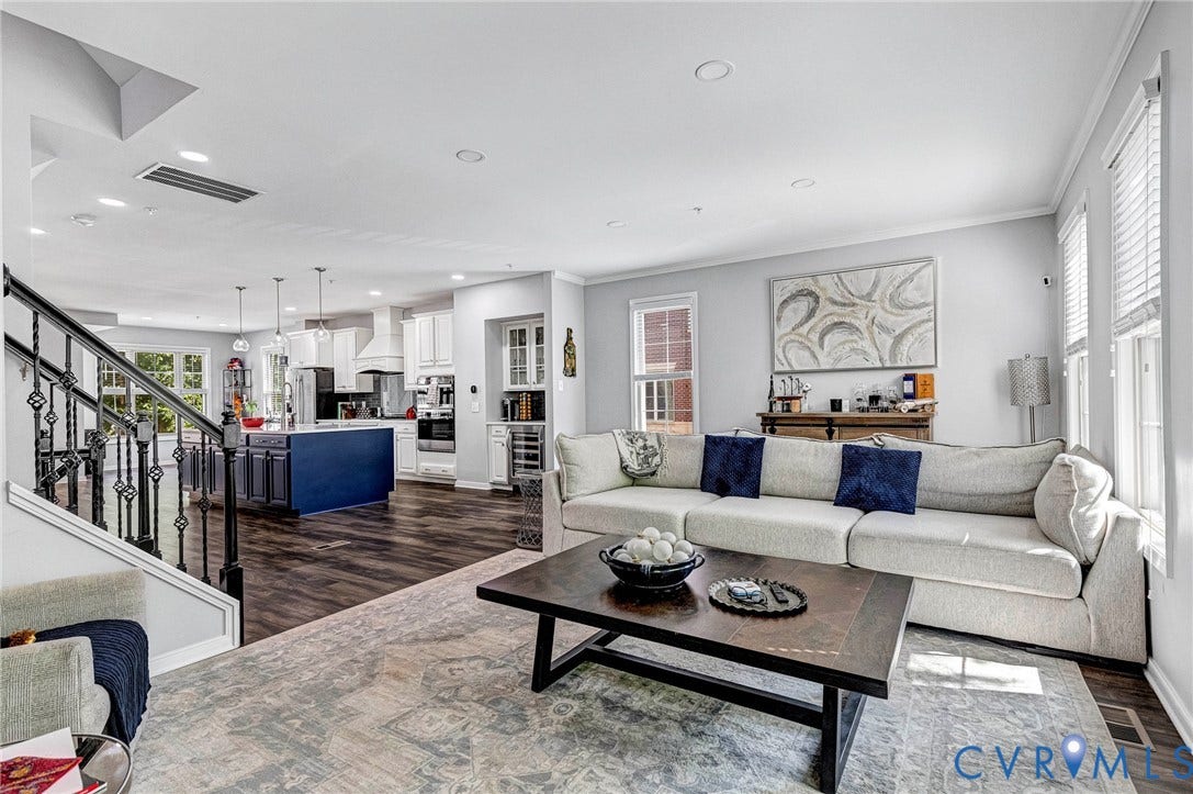 Open concept living space featuring wood-finish flooring, recessed lighting, and crown molding