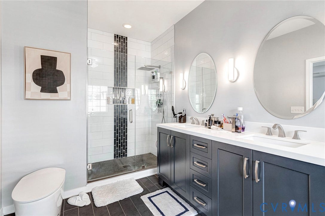 Bathroom featuring a frameless glass shower enclosure with subway tile and a vertical accent band