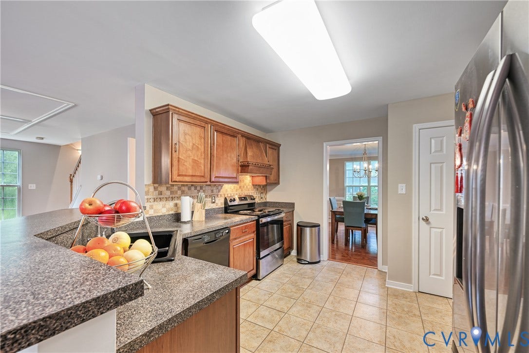 519 N Timber Tribe, Lake Anna, Mineral, VA 23117 Kitchen featuring light wood cabinetry, a mosaic tile backsplash, and dark speckled countertops