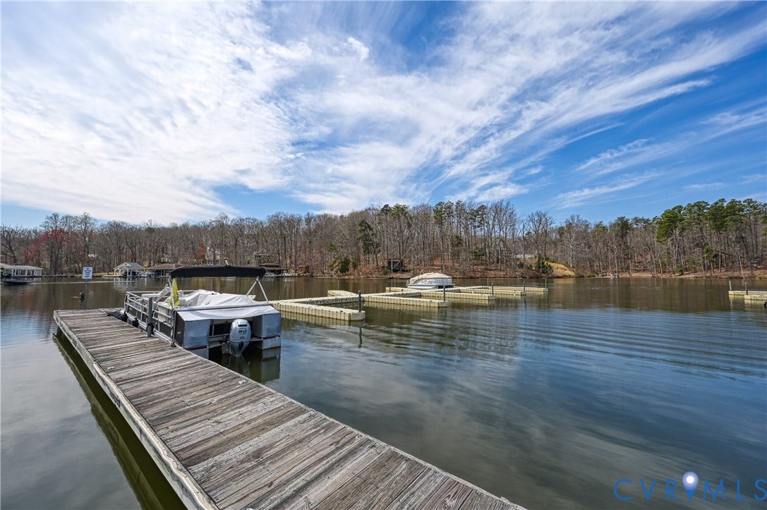 519 N Timber Tribe, Lake Anna, Mineral, VA 23117 Expansive waterfront common area featuring a wooden dock, multiple floating dock sections, and a natural treeline perimeter
