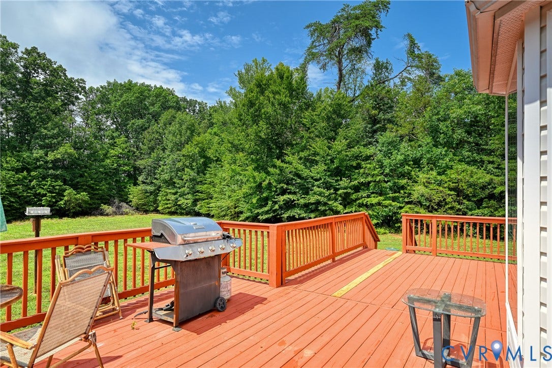 519 N Timber Tribe, Lake Anna, Mineral, VA 23117 Expansive red-stained deck with natural wood railing overlooking a grassy yard area