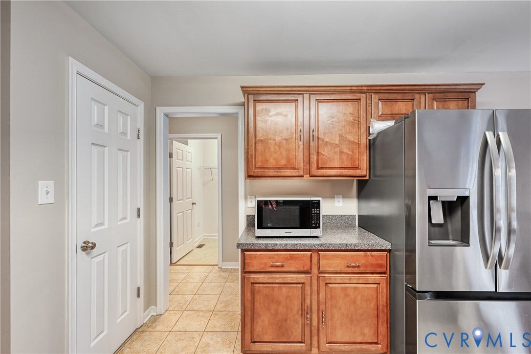 519 N Timber Tribe, Lake Anna, Mineral, VA 23117 Kitchen area with wood-finish cabinetry, speckled countertops, and stainless steel refrigerator