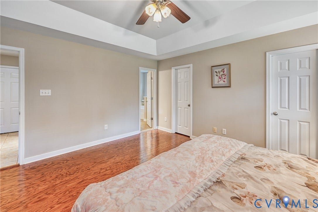 519 N Timber Tribe, Lake Anna, Mineral, VA 23117 Spacious interior room featuring wood-finish flooring, a tray ceiling, and a ceiling fan with light fixture