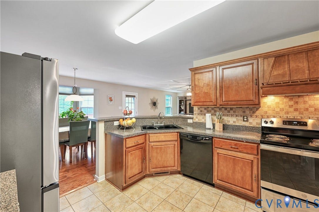 519 N Timber Tribe, Lake Anna, Mineral, VA 23117 Kitchen featuring wood cabinetry, tiled flooring, dark countertops, a mosaic tile backsplash, and stainless steel appliances