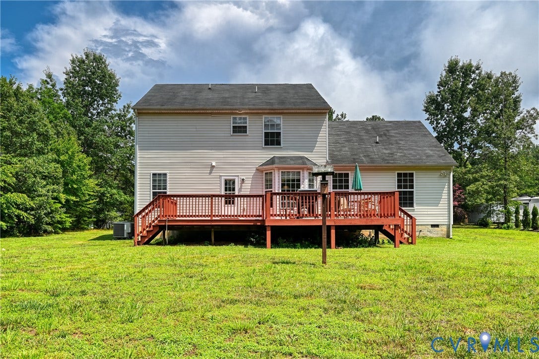 519 N Timber Tribe, Lake Anna, Mineral, VA 23117 Spacious backyard featuring a multi-level wood deck with stairs, a bay window, and mature trees bordering the property