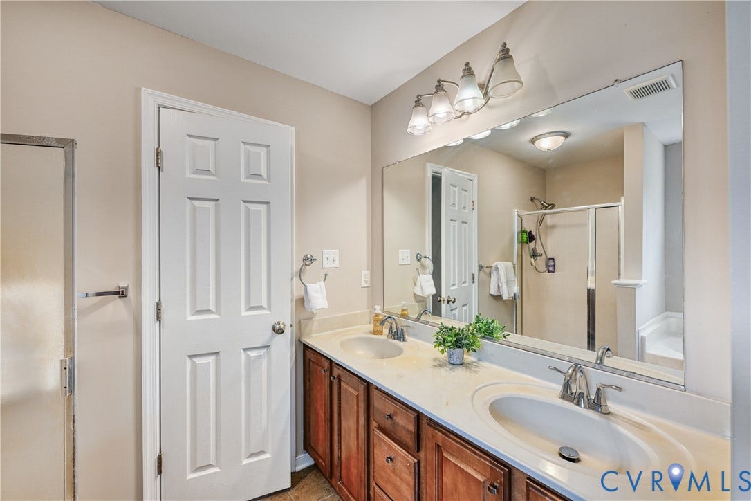 519 N Timber Tribe, Lake Anna, Mineral, VA 23117 Double vanity featuring wood-finish cabinetry and light-toned countertops