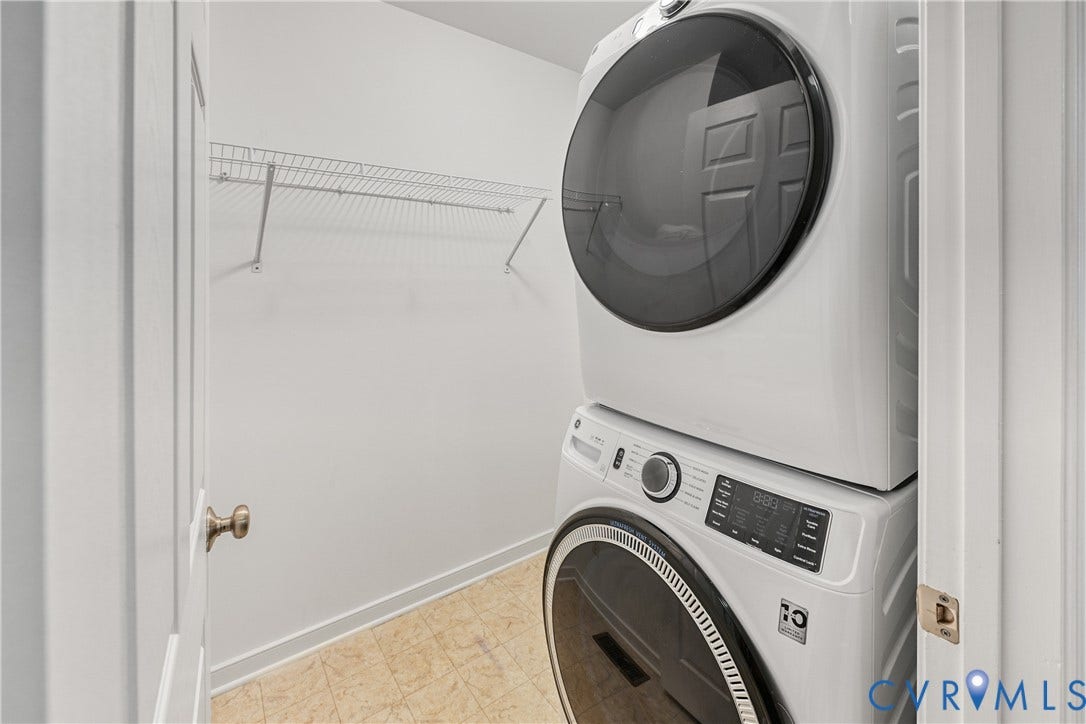 519 N Timber Tribe, Lake Anna, Mineral, VA 23117 Laundry area featuring a stacked washer and dryer unit, white wire shelving, and light-toned vinyl flooring