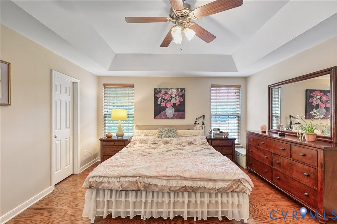 519 N Timber Tribe, Lake Anna, Mineral, VA 23117 Spacious 1st floor primary featuring tray ceilings, wood-finish flooring, a ceiling fan, and two windows with blinds