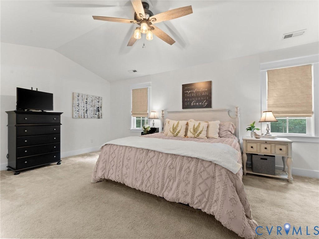 Spacious Primary Suite featuring vaulted ceilings and ensuite bath