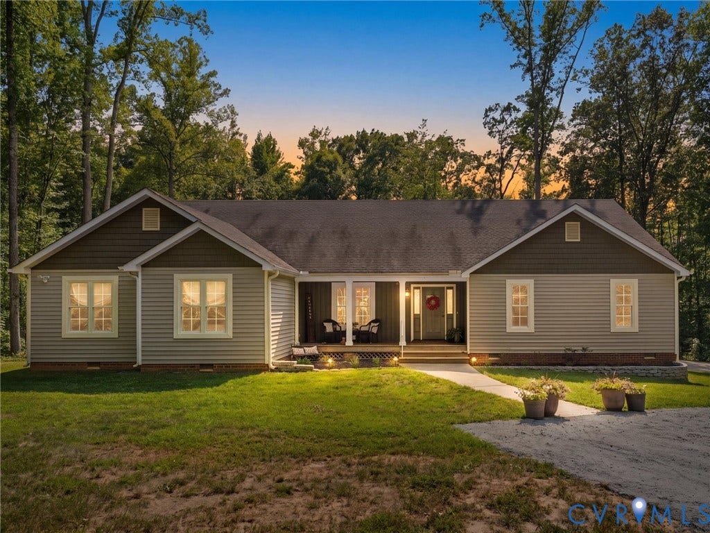Ranch-style residence featuring light gray siding and dark brown shake accents