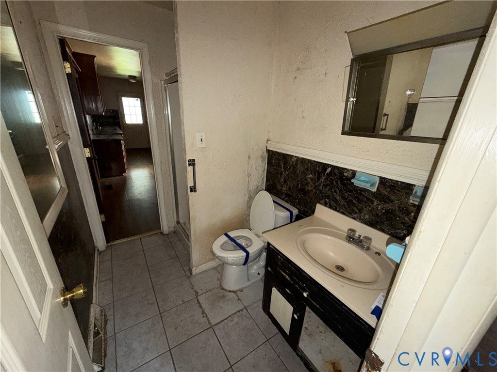 1121 E Booker Circle, Petersburg, VA 23803 Bathroom featuring a vanity with an integrated sink, a medicine cabinet, a toilet, and gray tile flooring