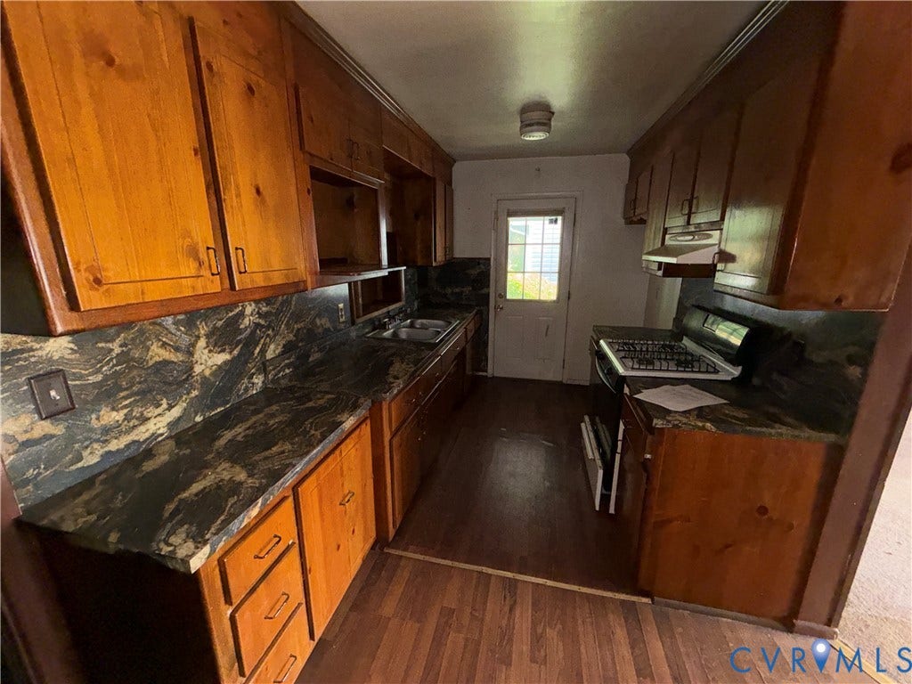 1121 E Booker Circle, Petersburg, VA 23803 Galley kitchen with wood-finish cabinetry, patterned countertops, and a double basin sink