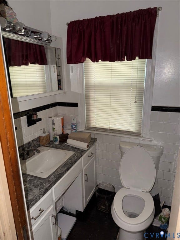 3605 Dill Road, Henrico, VA 23222 Bathroom featuring a white vanity with a patterned countertop, a wall-mounted medicine cabinet, white subway tile walls, and a window with blinds